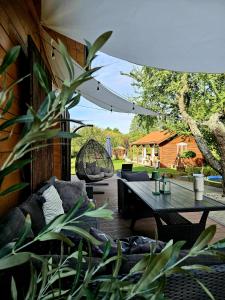 a patio with a wooden table and chairs and a tree at STACJA RUDA in Złota Wieś