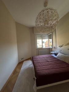 a bedroom with a large bed and a chandelier at The Green Nest Perugia in Perugia