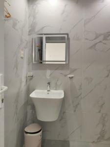 une salle de bain blanche avec un lavabo et des toilettes dans l'établissement Spacious 4-Bedroom Villa near Azaiba Beach, Muscat, à Mascate