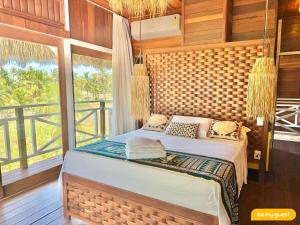 a bedroom with a bed in a room with a window at Vila Pukara - Moitas in Praia de Moitas