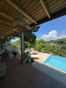 an outdoor patio with a swimming pool and a roof at Lady Aura Casitas in Cabo Rojo, Puerto Rico in Cabo Rojo