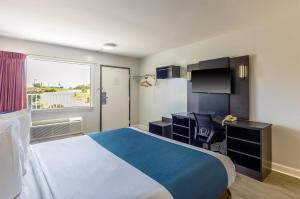 a hotel room with a bed and a desk and a television at Motel 6 Culpeper, VA in Culpeper