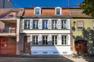 a white house with a red roof and white windows at Le Green Escape in Sélestat