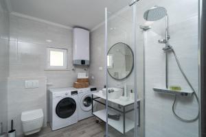 a bathroom with a washing machine and a sink at The Loft in Mokošica +29 photos