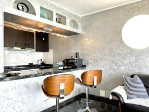a kitchen with two chairs and a counter with a stove at Onyx apartment in Puerto del Carmen