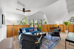 ein Wohnzimmer mit einem blauen Sofa und einem Tisch in der Unterkunft Unique Dome Retreat with Deck 1 mile to UF Stadium in Gainesville