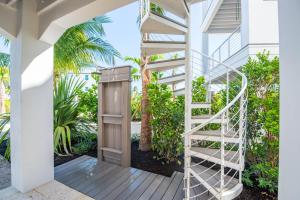 a staircase leading up to a house with palm trees at New Luxury Home in Private Community - with Pool, Beach & Pickleball Court in Marathon