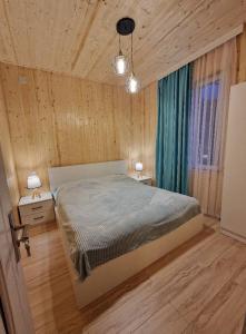 ein Schlafzimmer mit einem großen Bett in einem Zimmer mit Holzwänden in der Unterkunft Bacho's cottages Mzetamze 2 in Mzet'amze + 2 Fotos