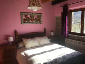 Un dormitorio con una cama y una pared rosa. en Apartamentos Besande, en Besande