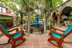 two chairs sitting in front of a fountain at Hotel Playa Salguero By GEH Suites in Santa Marta