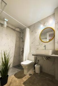 アルテミダにあるMiracle Luxury Suitesのトイレ、洗面台、鏡を備えたバスルーム