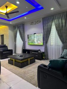 a living room with a couch and a tv at Cozy 4 bedroom at community 18 near spintex in Spintex