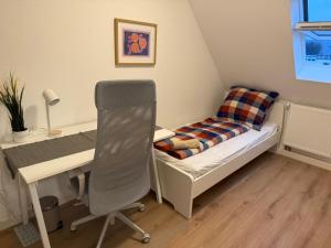 a bedroom with a desk and a bed and a chair at Zimmer direkt an dem Rheinsteig neben der WHU mitten im Zentrum von Vallendar in Vallendar