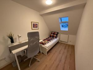 a small room with a desk and a bed and a chair at Zimmer direkt an dem Rheinsteig neben der WHU mitten im Zentrum von Vallendar in Vallendar