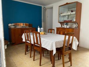a dining room table with chairs and a blue wall at Casa na praia- Maia in Maia