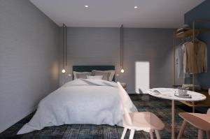 a bedroom with a bed and a table with a chair at Hôtel Kempf in Colmar