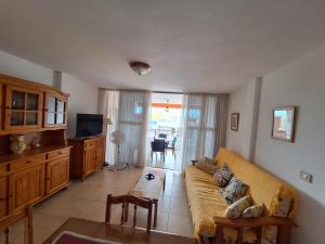 una sala de estar con un sofá y una mesa en Gloria Apartament, en Puerto Naos