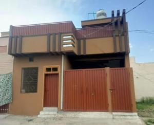 a house with a red fence and a red door at Ibrahim flats Mardan in Mardan