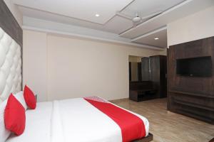 a bedroom with a bed and a flat screen tv at Hotel O Subhadra Residency in Meerut +25 photos