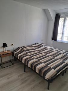 a bed in a room with a table and a window at Maison confortable sur RN6 in Armeau