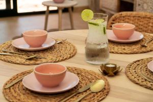 einem Holztisch mit Tellern und Tassen und einer Vase in der Unterkunft Casita Amor- Monaco 9- Hacienda del Alamo in Corverica