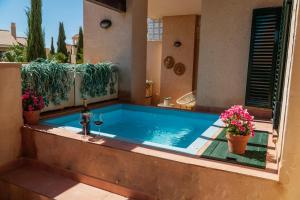 einen Pool im Hinterhof mit Pflanzen und Blumen in der Unterkunft Casita Amor- Monaco 9- Hacienda del Alamo in Corverica