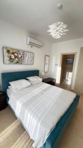 una camera da letto con un grande letto bianco con un lampadario di Frontline Paradise on the Water's edge in Tatlisu, North Cyprus a Famagusta