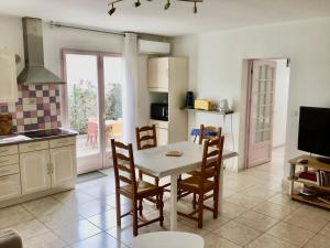 a kitchen and dining room with a table and chairs at Appartement avec extérieur et parking gratuit in Perpignan