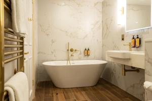 a white bathroom with a tub and a sink at Fernhill Hotel & Estate in Clonakilty