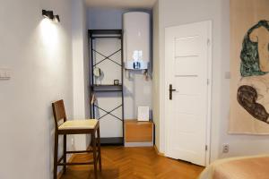 a room with a bed and a chair and a door at Egon Schiele Apartment in Český Krumlov +9 photos