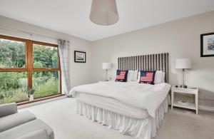 ein weißes Schlafzimmer mit einem großen Bett und einem Fenster in der Unterkunft River Cottage - Causeway Coast - Coleraine in Fish Loughan