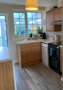 a kitchen with a sink and a stove top oven at April Cottage in Lymington