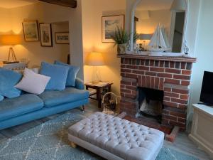 a living room with a couch and a fireplace at April Cottage in Lymington