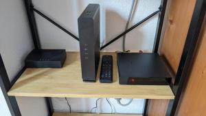 a router and a laptop on a wooden shelf at Appartement 3 pieces 6 personnes, 2 chambres, avec piscine l'été et au pied des pistes l'hiver in Arvieux