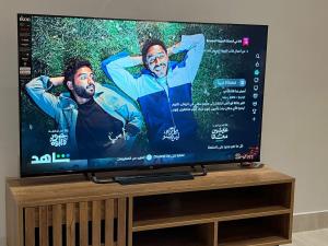 a flat screen tv sitting on top of a wooden stand at Modern apartment with elegant design in Dhahran +3 photos