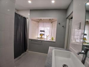 a bathroom with a shower and a sink and a window at Comfort Zone at The Ridge E17 in Ocho Rios +21 photos