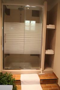 a bathroom with a glass window with a blind at Le Mas Des Glycines in Les Vignères