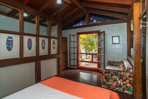 a large room with a bed and a window at Villa do Portinho - Casas em frente à Praia in Ilhabela