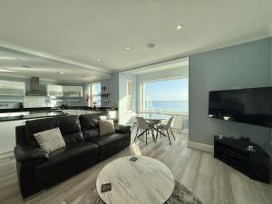a living room with a couch and a table at Sunnybeach in Seaton