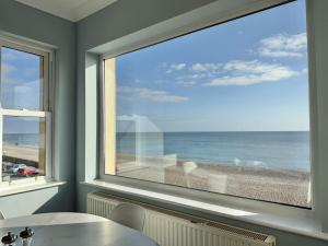 a window with a view of the beach at Sunnybeach in Seaton