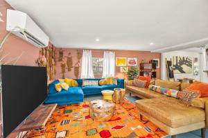 a living room with blue couches and a rug at Saltwater Pool - HotTub - Games - Good Vibes Only! in Indio