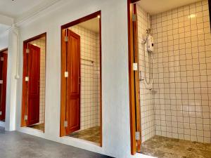 a bathroom with two mirrors and a walk in shower at Secret Corner Boutique Hostel in Chiang Rai +31 photos