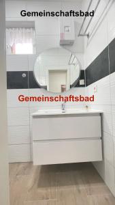 a bathroom with a white sink and a mirror at Kim Homestay B Zimmer 2 in Sömmerda