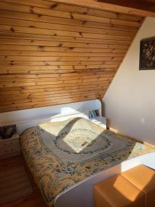 una cama en una habitación con techo de madera en Kampinówka, 