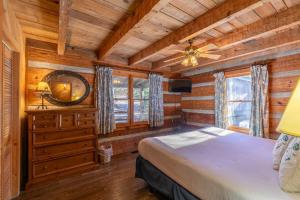 a bedroom in a log cabin with a bed and a mirror at A River Runs Through It in Valle Crucis