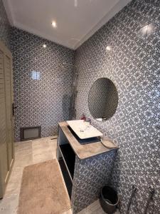 a bathroom with a sink and a mirror at Traditional Aicha House in Tozeur