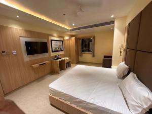 a hotel room with a bed and a flat screen tv at Hotel The Elite in Jabalpur