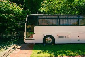 a white bus parked in the grass next to trees at Yura Green - Vacation STAY 65845v in Yura +4 photos