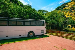 a white bus parked next to a fence at Yura Green - Vacation STAY 65845v in Yura