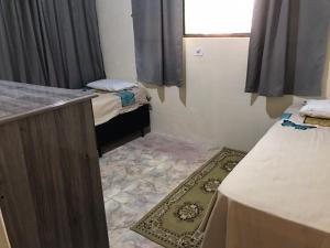 a small room with two beds and a window at Chalé Recanto Derrico in Santo Antônio do Pinhal